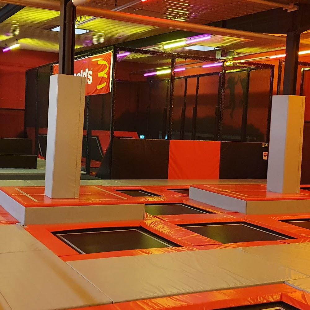 Indoor trampoline park with multiple trampolines.